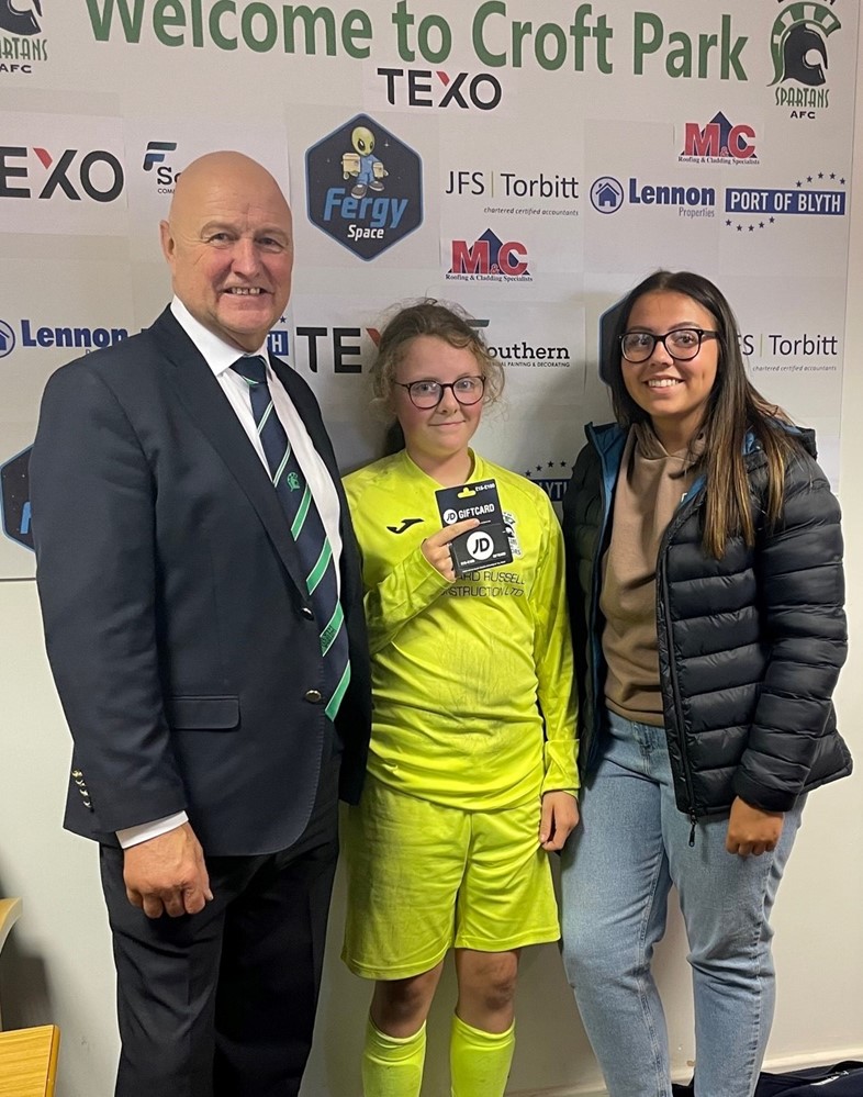 Spartans' “Girl of The Game”, Lilly Kinghorn is presented with her £25 JD Sports voucher by Niamh Dougan of Port Training Services, alongside Spartans Vice Chairman Kevin Scott.